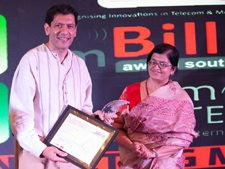 Rajesh Shah receiving the mBillionth trophy and plaque from Sudha Rao